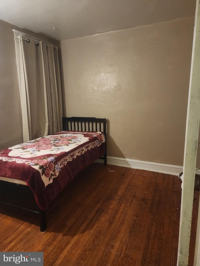 bedroom with dark wood-type flooring