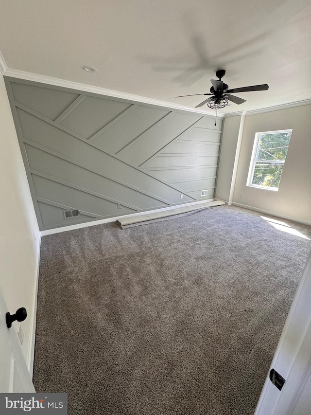 carpeted spare room featuring ornamental molding and ceiling fan