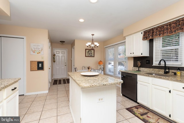 kitchen featuring dishwasher, sink, hanging light fixtures, light stone countertops, and a kitchen island