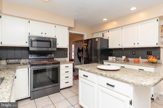 kitchen with a center island, white cabinets, decorative backsplash, appliances with stainless steel finishes, and light stone counters