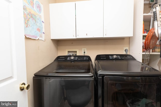 laundry room with cabinets and washing machine and clothes dryer