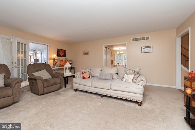 carpeted living room featuring a wealth of natural light and an inviting chandelier