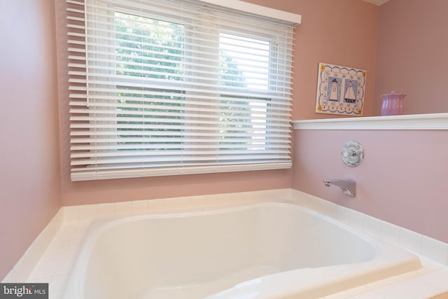 bathroom featuring plenty of natural light and tiled tub