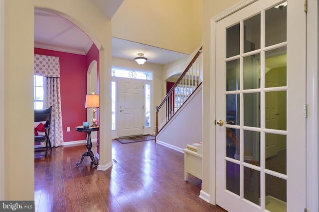 entrance foyer featuring hardwood / wood-style floors, plenty of natural light, and ornamental molding