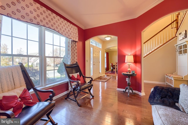 living area with hardwood / wood-style flooring and crown molding