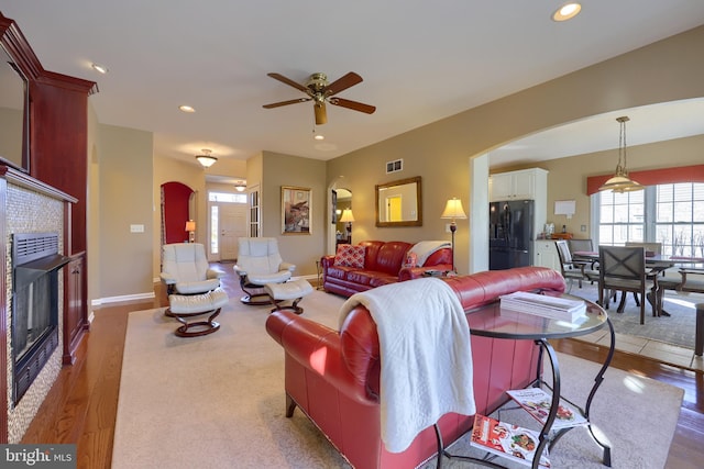 living room featuring ceiling fan and light wood-type flooring