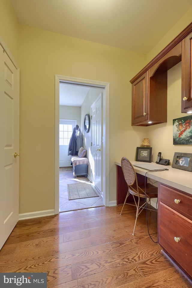 home office featuring built in desk and light hardwood / wood-style flooring