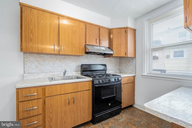 kitchen with black range with gas stovetop, decorative backsplash, and sink