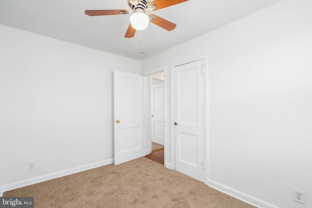 unfurnished bedroom with ceiling fan and light colored carpet