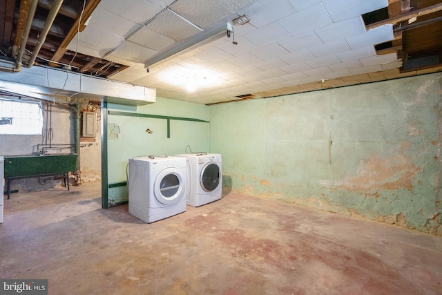 basement featuring washing machine and dryer, sink, and electric panel