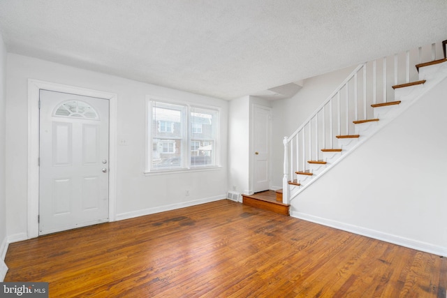 foyer with a textured ceiling and dark hardwood / wood-style floors