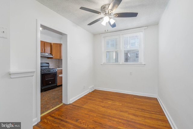 spare room with ceiling fan, wood-type flooring, and a textured ceiling