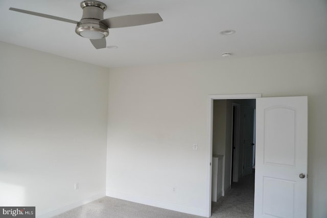 spare room featuring light colored carpet and ceiling fan