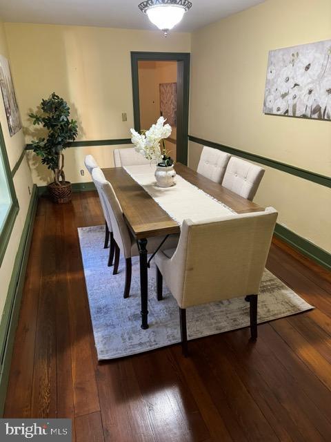 unfurnished dining area featuring dark hardwood / wood-style floors and a baseboard radiator