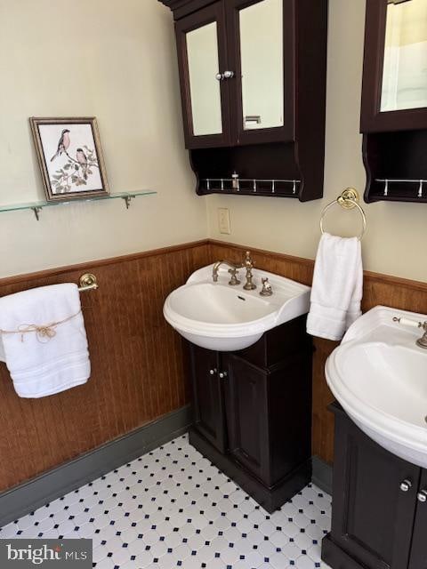 bathroom featuring vanity and wooden walls