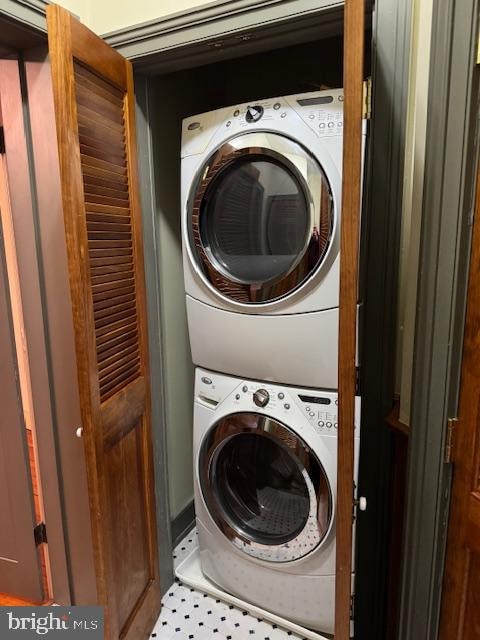 laundry room featuring tile patterned flooring and stacked washer / dryer