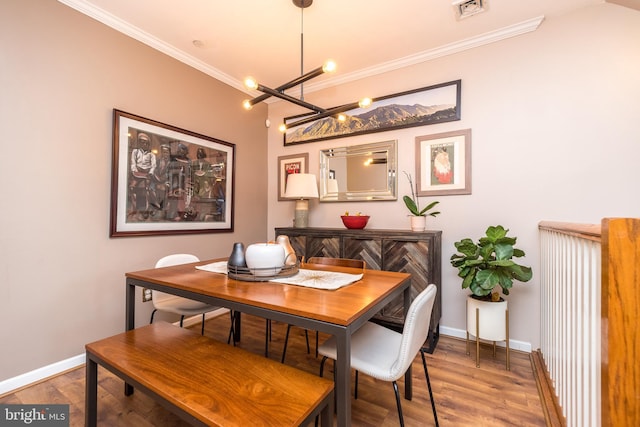 dining room featuring a chandelier, hardwood / wood-style floors, and ornamental molding