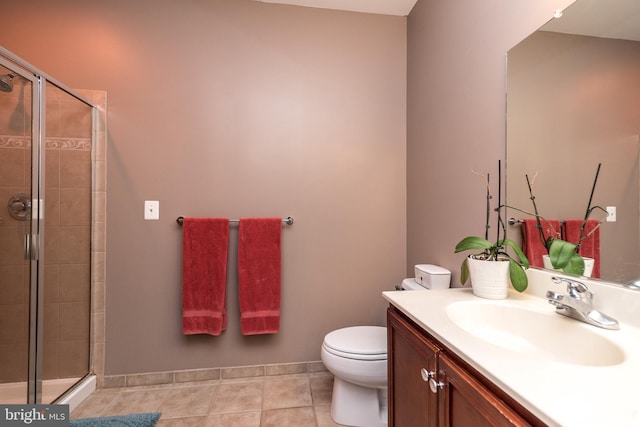 bathroom with tile patterned floors, vanity, a shower with shower door, and toilet