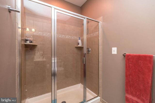 bathroom featuring a shower with shower door