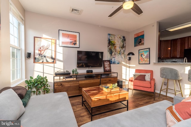 living room featuring ceiling fan and dark wood-type flooring