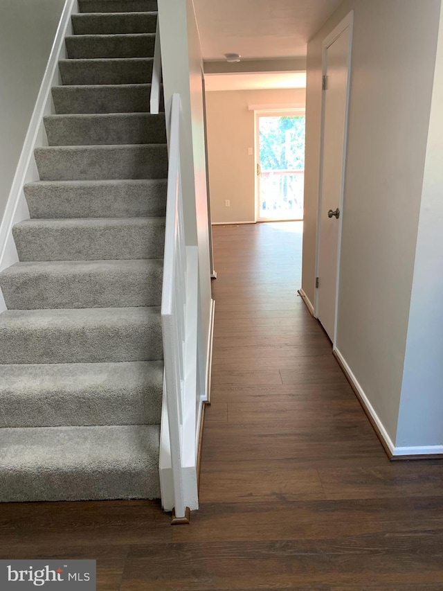 stairs featuring hardwood / wood-style floors