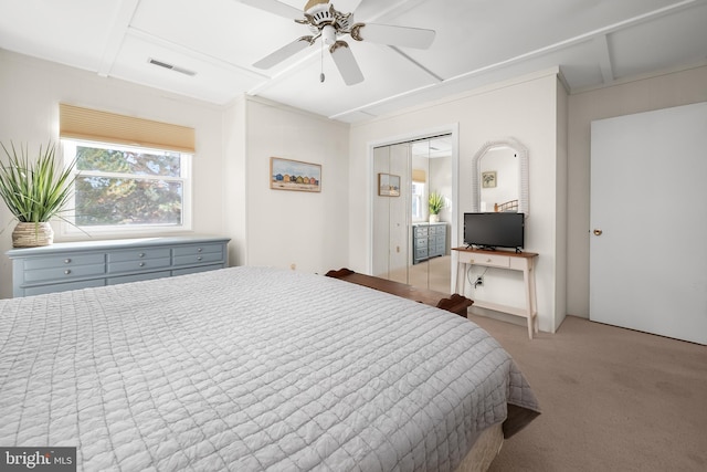 bedroom with light carpet, ceiling fan, and a closet