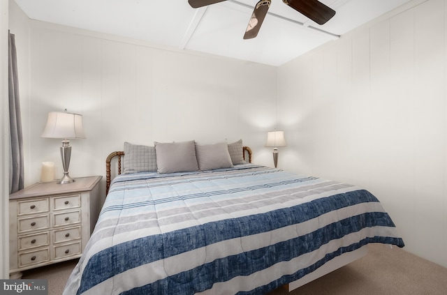 bedroom with wood walls, ceiling fan, and carpet flooring