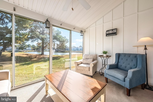 sunroom / solarium with ceiling fan, a water view, and vaulted ceiling