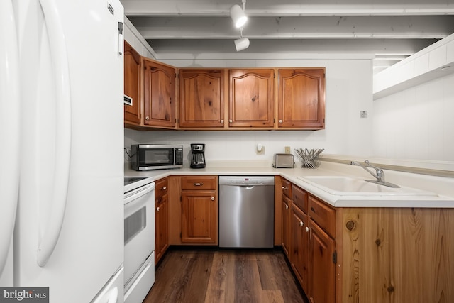 kitchen with appliances with stainless steel finishes, sink, and dark hardwood / wood-style flooring