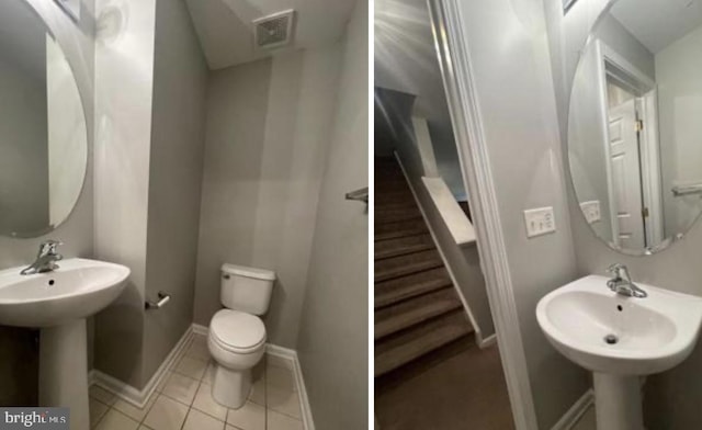 bathroom with toilet, sink, and tile patterned floors