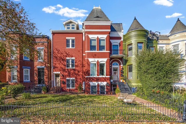 victorian house with a front yard and a balcony