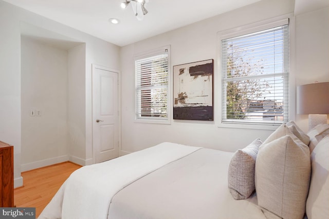 bedroom with hardwood / wood-style floors and multiple windows