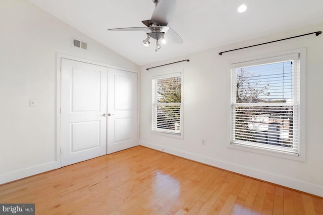 unfurnished bedroom with ceiling fan, wood-type flooring, lofted ceiling, and a closet