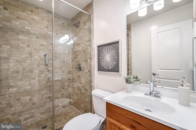 bathroom with vanity, an enclosed shower, and toilet