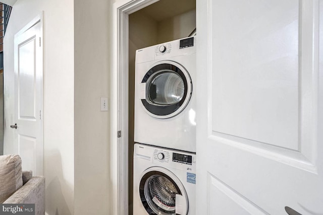 washroom featuring stacked washing maching and dryer