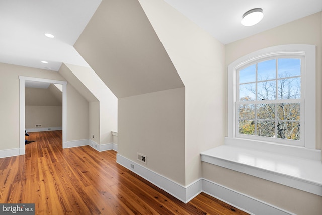 additional living space featuring hardwood / wood-style floors and lofted ceiling