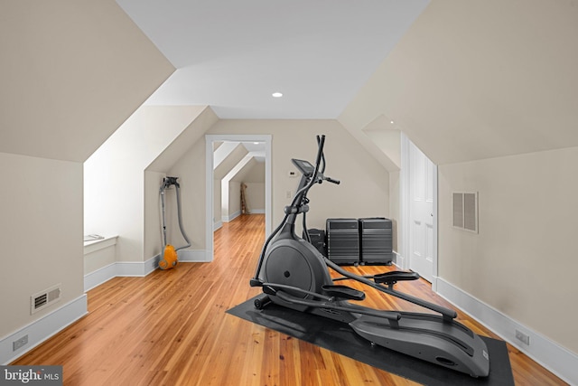 exercise room with light hardwood / wood-style flooring and lofted ceiling