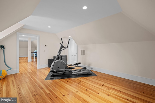 workout room featuring light hardwood / wood-style floors and lofted ceiling