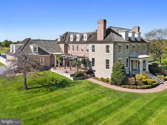 back of property featuring a lawn and a pergola