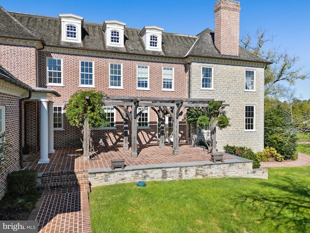 rear view of property featuring a yard and a patio area