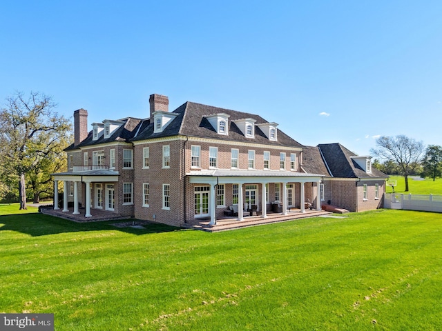 rear view of property with a yard and a patio area