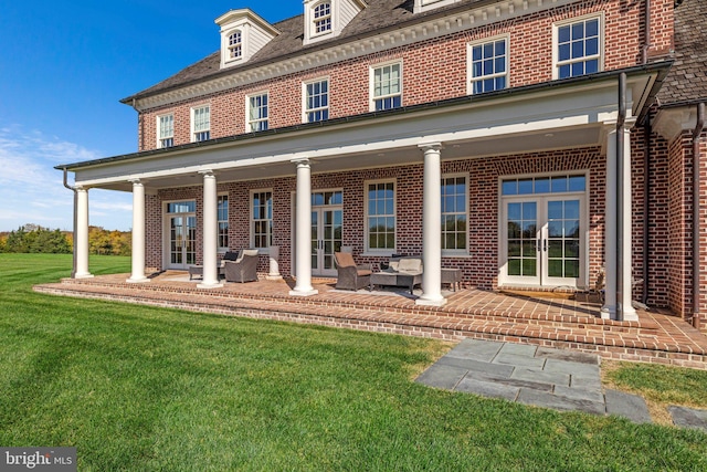 rear view of property featuring a lawn and french doors