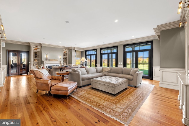 living room with french doors, light hardwood / wood-style floors, and ornamental molding