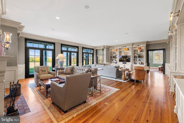 living room featuring french doors, light hardwood / wood-style floors, and crown molding