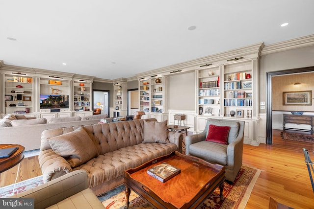 living room featuring built in features, ornamental molding, and light hardwood / wood-style flooring