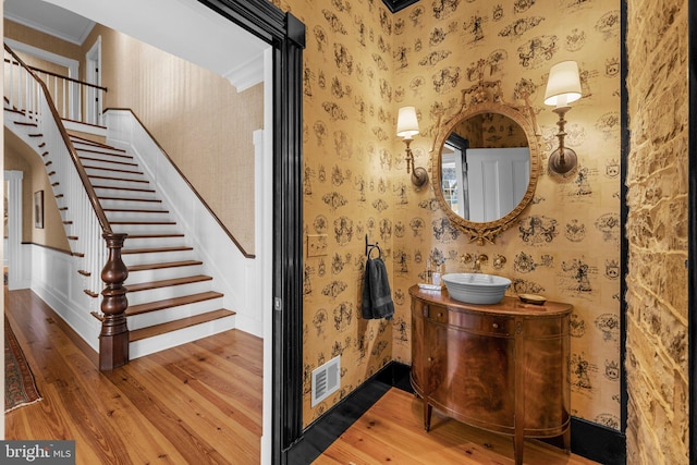 bathroom featuring vanity, hardwood / wood-style flooring, and ornamental molding