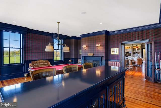 kitchen featuring decorative light fixtures, hardwood / wood-style flooring, and crown molding