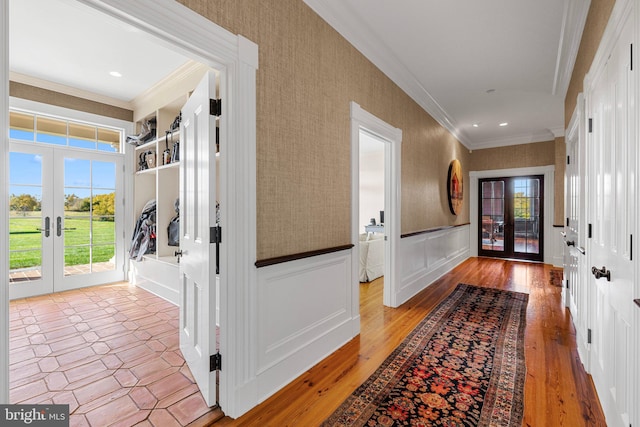 doorway to outside with light wood-type flooring, crown molding, and french doors