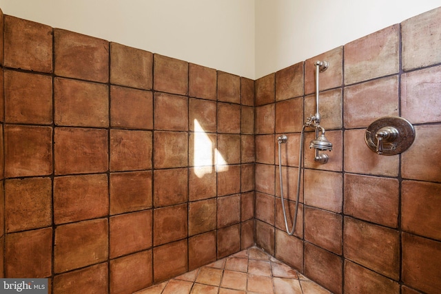 bathroom featuring tile patterned flooring and tiled shower