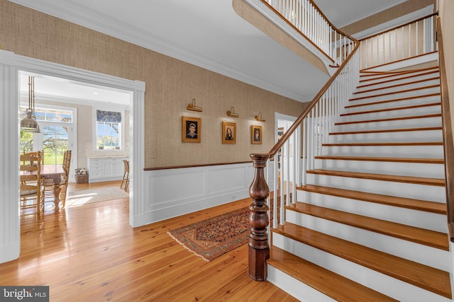 stairway featuring hardwood / wood-style floors and crown molding